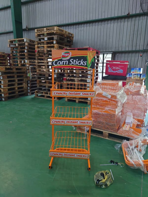 Kệ trưng bày bánh ngọt Corn Stick với thiết kế màu cam, kết hợp tên thương hiệu, hình sản phẩm và slogan