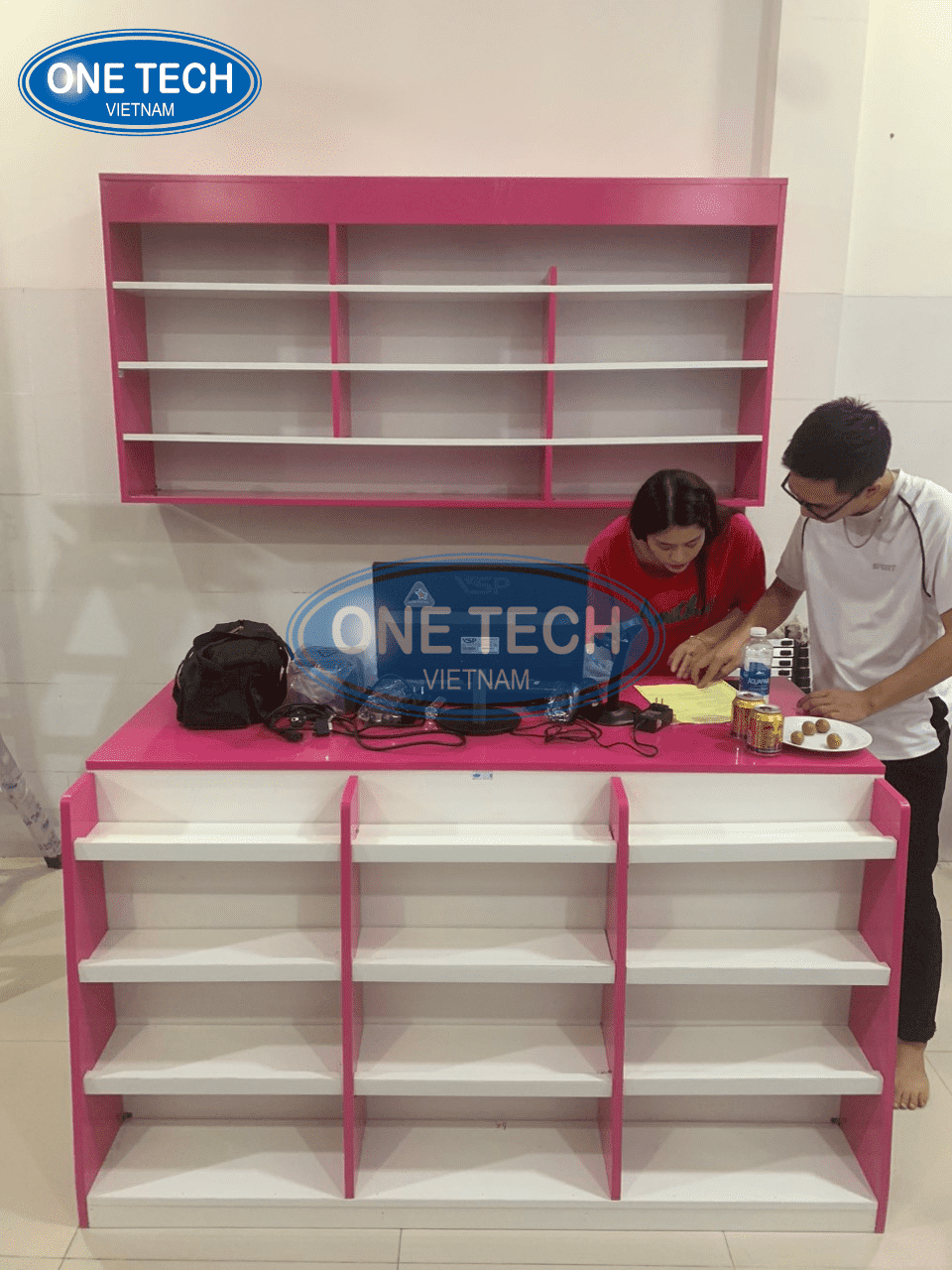 Kệ mini trước bàn thu ngân cùng tủ treo tường được thiết kế riêng cho Shop Bé Tuệ